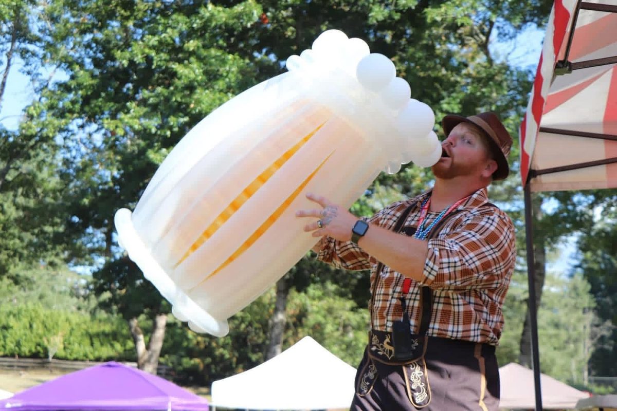 DJ Ben Holmes in lederhosen holding a giant balloon beer stein